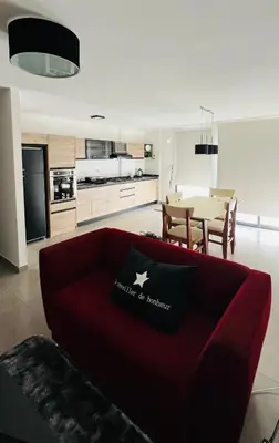 a living room with a red couch in a kitchen at Duplex temporario en Villa Carlos Paz in Villa Carlos Paz