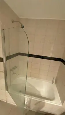 a glass shower door with a tub in a bathroom at Apartamento con piscina en pleno centro de cordoba in Cordoba