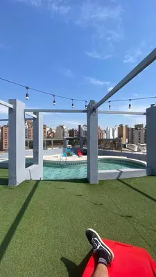 a person laying on the grass with their feet on a roof at Apartamento con piscina en pleno centro de cordoba in Cordoba