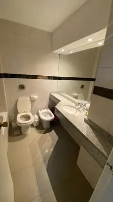 a bathroom with two sinks and a toilet and a mirror at Apartamento con piscina en pleno centro de cordoba in Cordoba