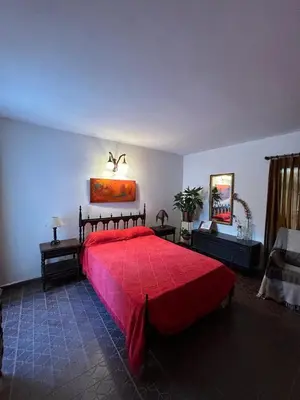 a bedroom with a large red bed in a room at Casa Jazmin in La Cuesta