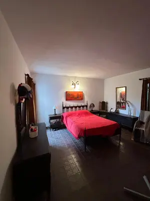 a bedroom with a red bed with a red comforter at Casa Jazmin in La Cuesta