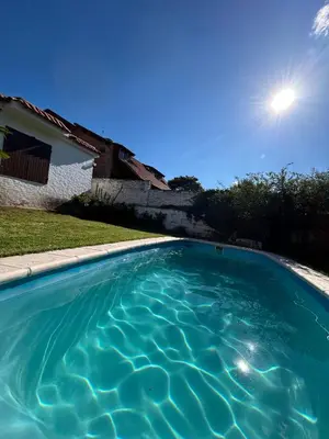 a swimming pool with blue water in front of a house at Casa Jazmin in La Cuesta