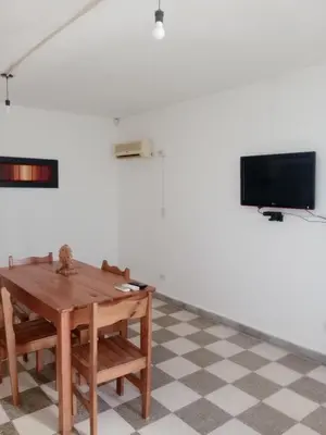 a dining room with a table and a tv at El Quebrachito in Alta Gracia