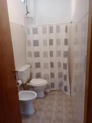 a bathroom with a toilet and a shower curtain at El Quebrachito in Alta Gracia