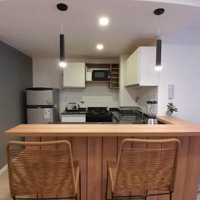 a kitchen with a counter top with two chairs at Departamento temporal in Cordoba