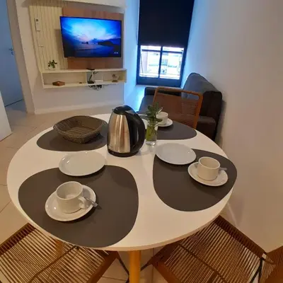 a table with plates and a kettle and a television at Departamento temporal in Cordoba