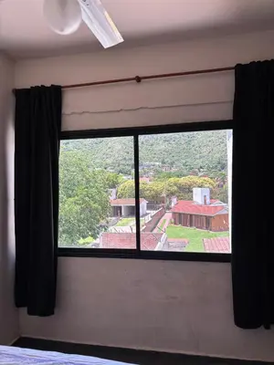 a window with a view of a house at Dpto monoambiente in Villa Carlos Paz