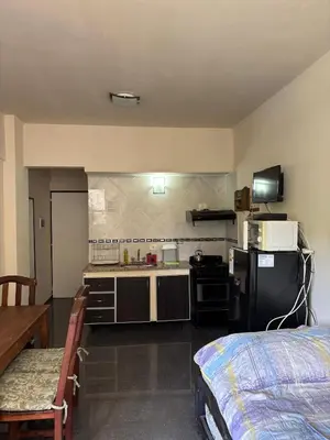 a small kitchen with a stove and a refrigerator at Dpto monoambiente in Villa Carlos Paz