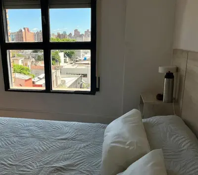 a bedroom with a bed and a window at Depto en Güemes in Cordoba