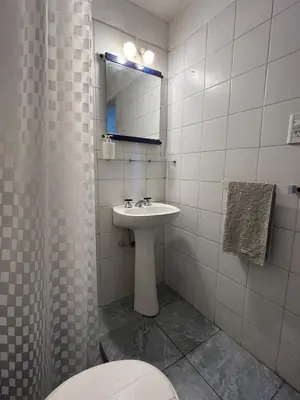 a bathroom with a sink and a toilet and a mirror at Depto en Güemes in Cordoba