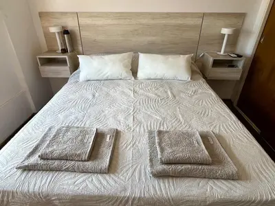 a bed with two towels on it with two night stands at Depto en Güemes in Cordoba