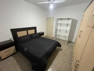 a bedroom with a black bed and a closet at Casa La Paz in Villa Carlos Paz