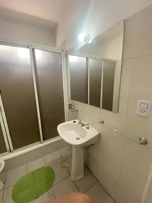 a white bathroom with a sink and a shower at Casa La Paz in Villa Carlos Paz