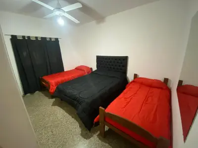 a bedroom with two beds and a ceiling fan at Casa La Paz in Villa Carlos Paz