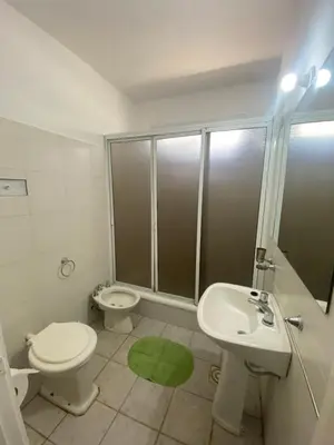 a bathroom with a toilet and a sink and a shower at Casa La Paz in Villa Carlos Paz