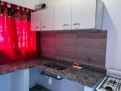 a kitchen with a sink and a red curtain at Casa La Paz in Villa Carlos Paz