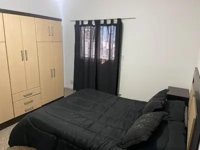 a bedroom with a black bed and a window at Casa La Paz in Villa Carlos Paz