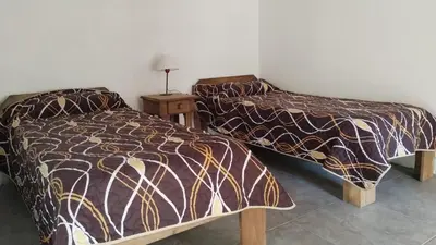 a bedroom with two beds and a table with a lamp at Departamento España in Santa Rosa de Calamuchita