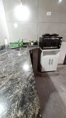 a kitchen counter with a sink and a microwave at Departamento España in Santa Rosa de Calamuchita