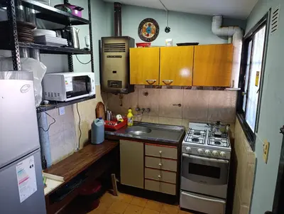 a small kitchen with a stove and a sink at Chalet BERNI in Villa Carlos Paz