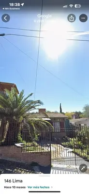 a picture of a fence with a palm tree behind it at Chalet BERNI in Villa Carlos Paz
