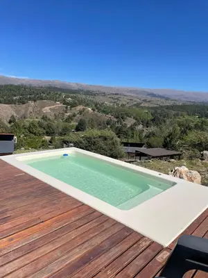 a swimming pool on the deck of a house at Medio Cielo Cabaña de Montaña in Rincón de Luna