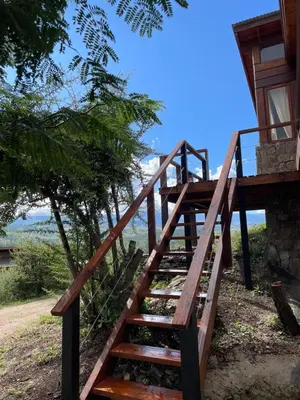 a wooden staircase leading up to a house at Medio Cielo Cabaña de Montaña in Rincón de Luna