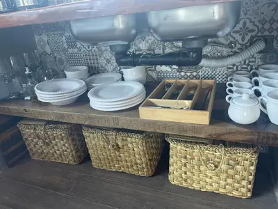 a shelf with plates and bowls and baskets on it at Medio Cielo Cabaña de Montaña in Rincón de Luna