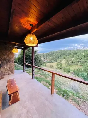 a porch with a table and a view of a field at Medio Cielo Cabaña de Montaña in Rincón de Luna