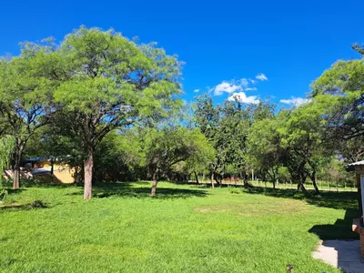 a park with green grass and trees on a sunny day at Refugios del Alma 24 in Villa de Las Rosas
