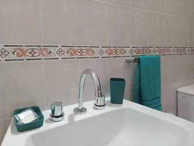 a white sink in a bathroom with a green towel at Refugios del Alma 24 in Villa de Las Rosas