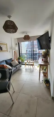 a living room with a couch and a flat screen tv at Dpto zona GRAL PAZ a cuadras de la Clínica Reina Fabiola in Cordoba