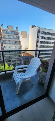 a white chair sitting on top of a balcony at Dpto zona GRAL PAZ a cuadras de la Clínica Reina Fabiola in Cordoba