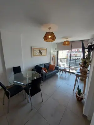 a living room with a couch and a glass table at Dpto zona GRAL PAZ a cuadras de la Clínica Reina Fabiola in Cordoba