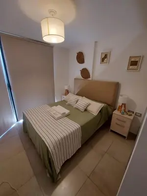 a small bedroom with a bed and a lamp at Dpto zona GRAL PAZ a cuadras de la Clínica Reina Fabiola in Cordoba