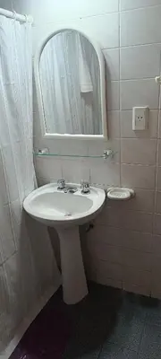 a bathroom with a white sink and a mirror at Departamento 1D Centro in Cordoba