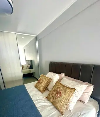a bed with two pillows and a mirror at Depto Elegante, Centrico, Calef Central, Cochera in Villa Carlos Paz