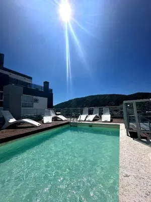 a swimming pool with chairs and the sun in the sky at Depto Elegante, Centrico, Calef Central, Cochera in Villa Carlos Paz