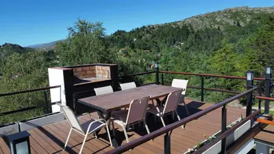a wooden deck with a table and chairs on it at Altos de Cumbrecita - Casa Suite in La Cumbrecita