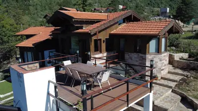 a house with a table and chairs on a deck at Altos de Cumbrecita - Casa Suite in La Cumbrecita