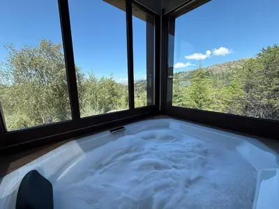 a bath tub in a room with two windows at Altos de Cumbrecita - Casa Suite in La Cumbrecita