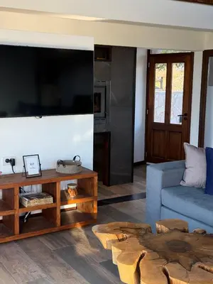 a living room with a large flat screen tv at Altos de Cumbrecita - Casa Suite in La Cumbrecita
