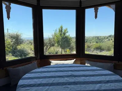 a bedroom with a bed and three windows at Altos de Cumbrecita - Casa Suite in La Cumbrecita
