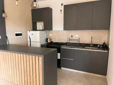 a kitchen with black cabinets and a white refrigerator at Casa Las Breas del Champaquí in Las Tapias