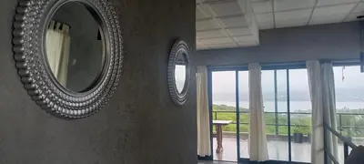 two mirrors on a wall in a room with windows at El Descanso in San Roque