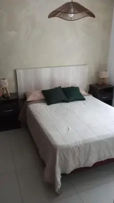 a bedroom with a large white bed with two night stands at Dpto 1 dormitorio céntrico piscina cochera in Villa Carlos Paz