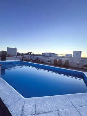 a swimming pool with blue water on top of a building at Dpto 1 dormitorio céntrico piscina cochera in Villa Carlos Paz