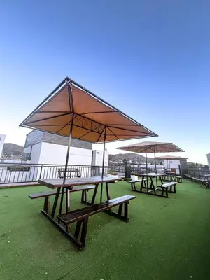 a group of picnic tables with a large umbrella at Dpto 1 dormitorio céntrico piscina cochera in Villa Carlos Paz