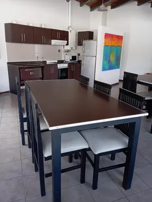 a kitchen with a table and chairs in a room at Dpto 1 dormitorio céntrico piscina cochera in Villa Carlos Paz